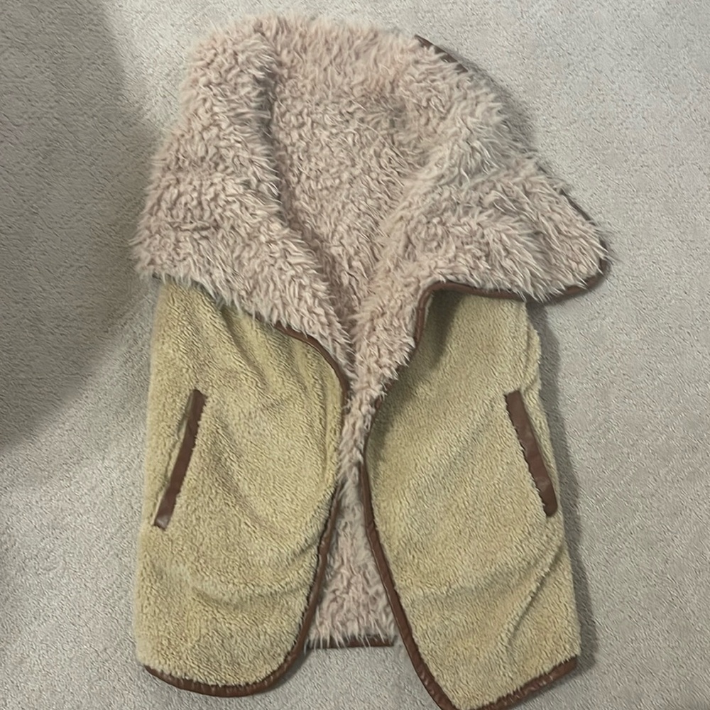 Reversible fur/fleece Vest. Brown faux leather trim. Pockets on one side.